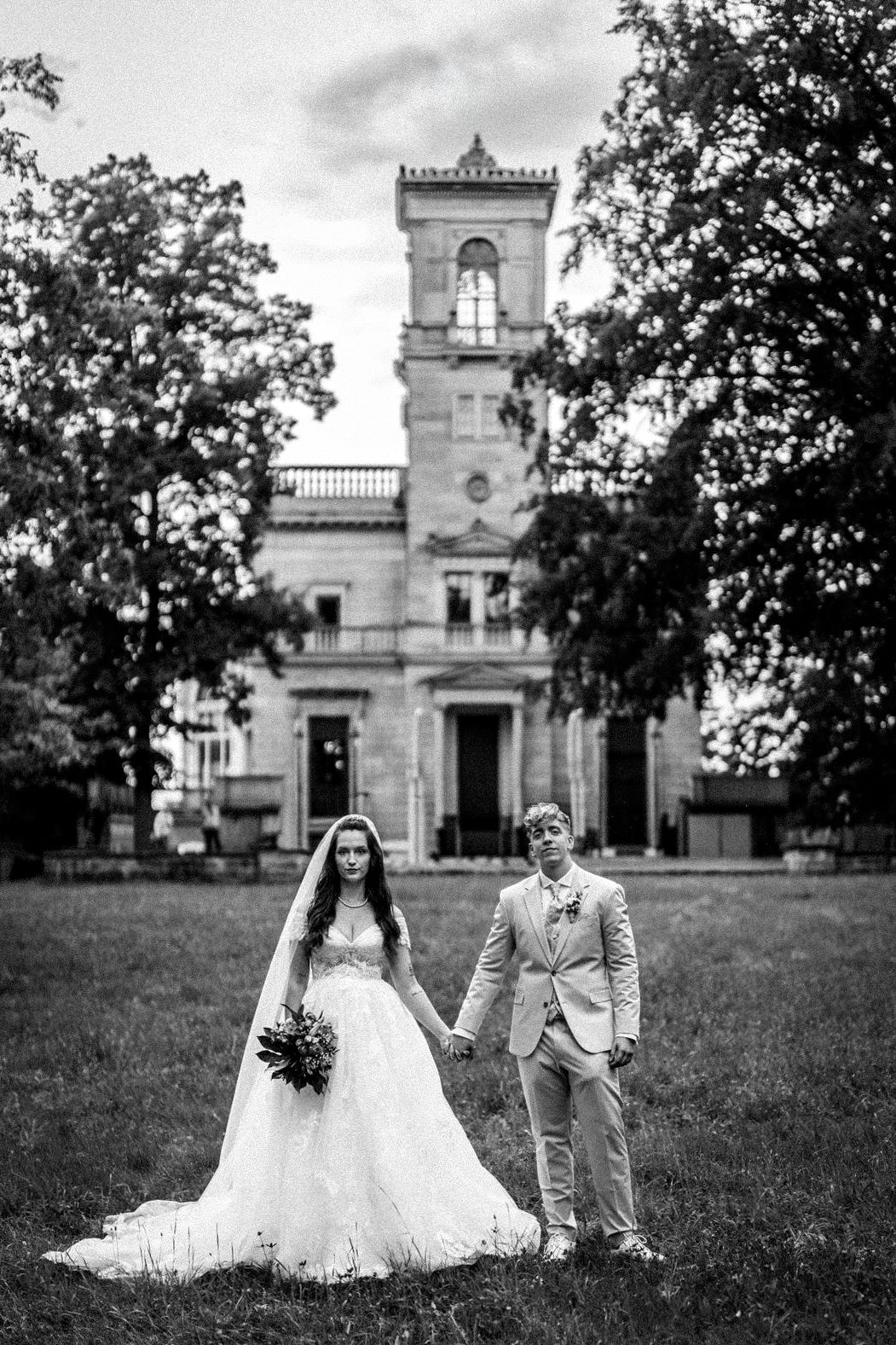 Brautpaar mit Strauß Brautpaar, das sich umarmt, mit einem Blumenstrauß und liebevollem Blick zueinander.